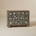 High-end studio product shot of a 3-drawer chest with intricate black and white floral bone inlay on a clean beige background. Crystal knobs, seamless pattern matching across drawers. Soft studio lighting, sharp focus, minimal shadows, luxury catalog style, 8K.