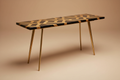 High-end studio product shot of a sleek console table with black and gold geometric resin inlay on a clean beige background. Modern sharp lines and brass legs. Soft studio lighting, sharp focus, minimal shadows, luxury catalog style, 8K.